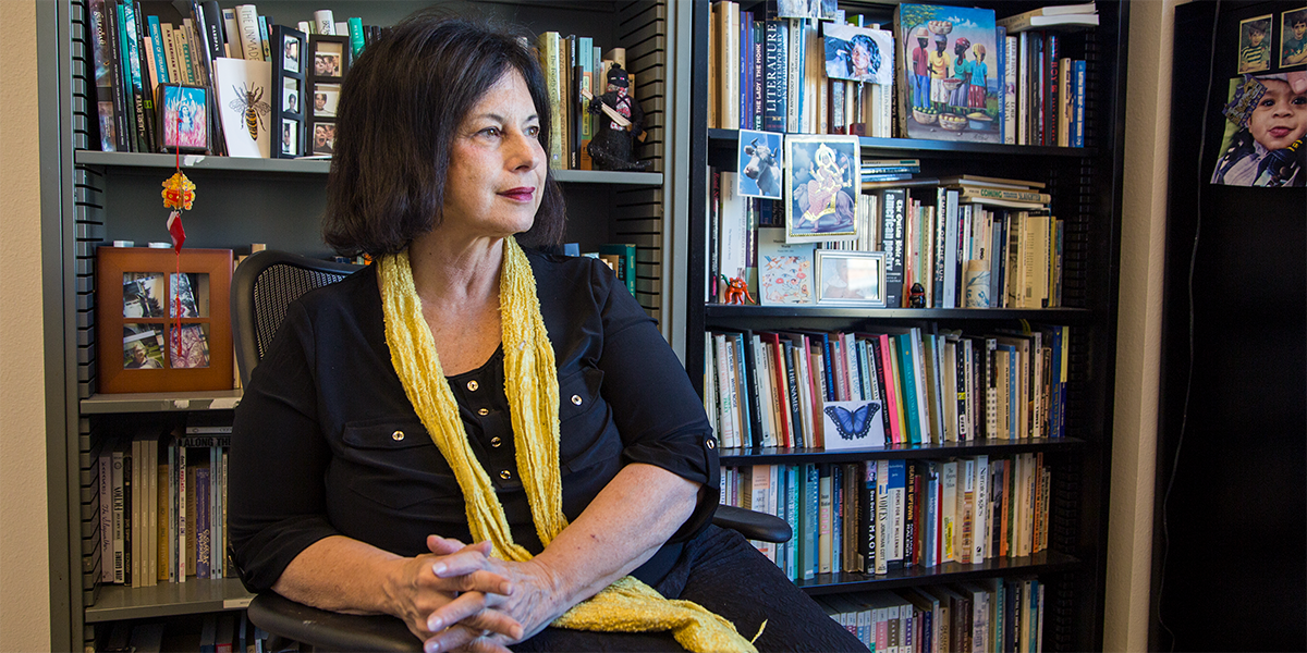 Photo of Maxine Chernoff seated in front of bookshelves